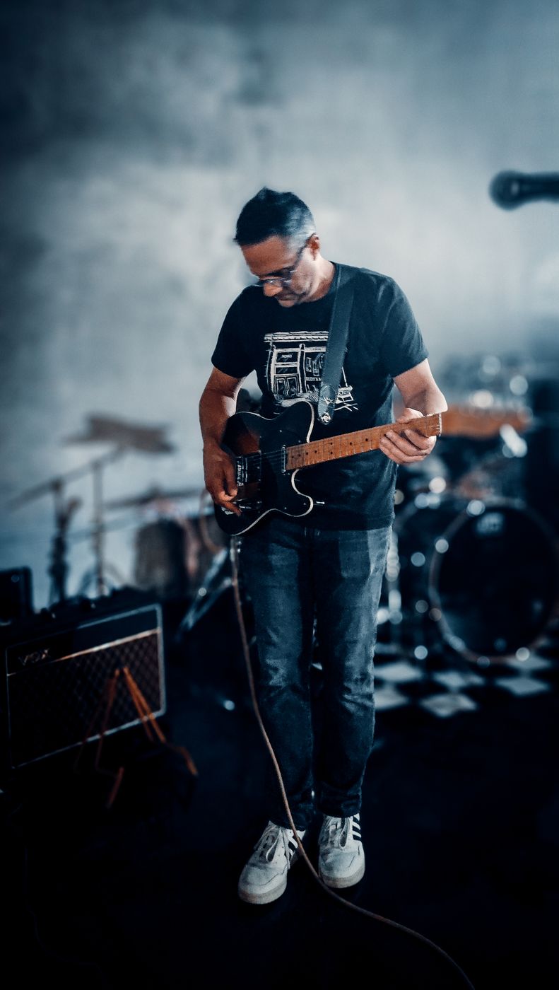 Guitarist on stage in front of the drum kit
