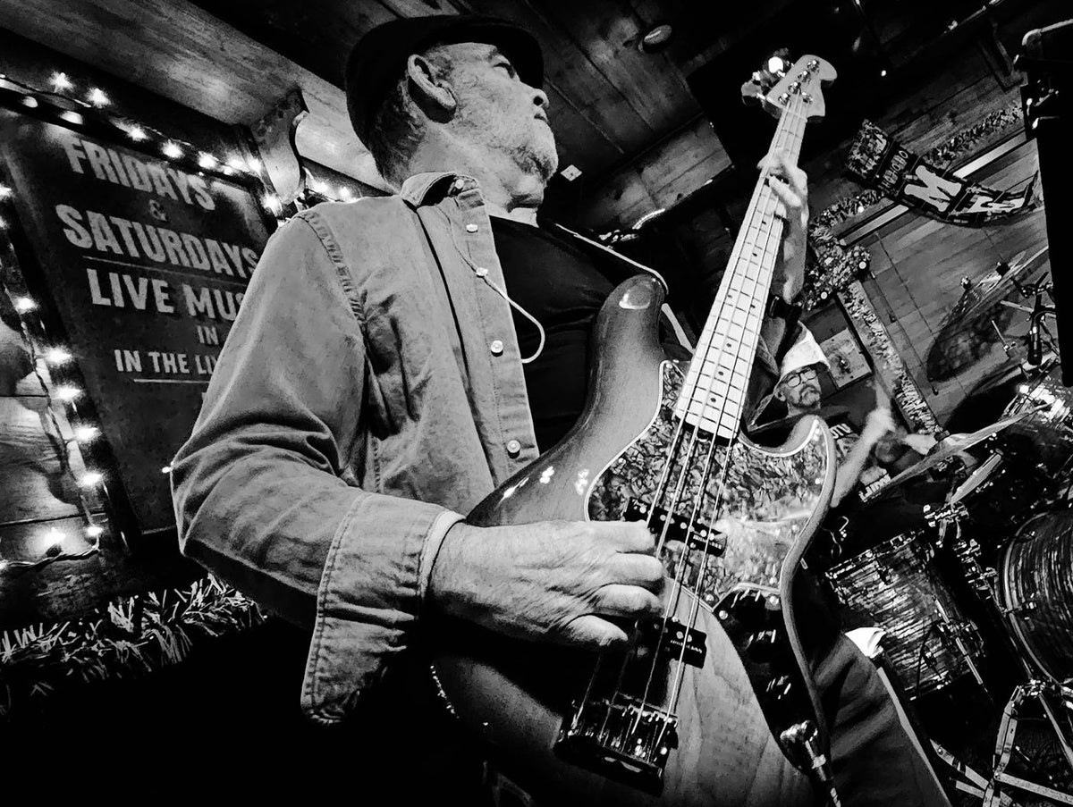 Bass player in black and white under the marquee lights