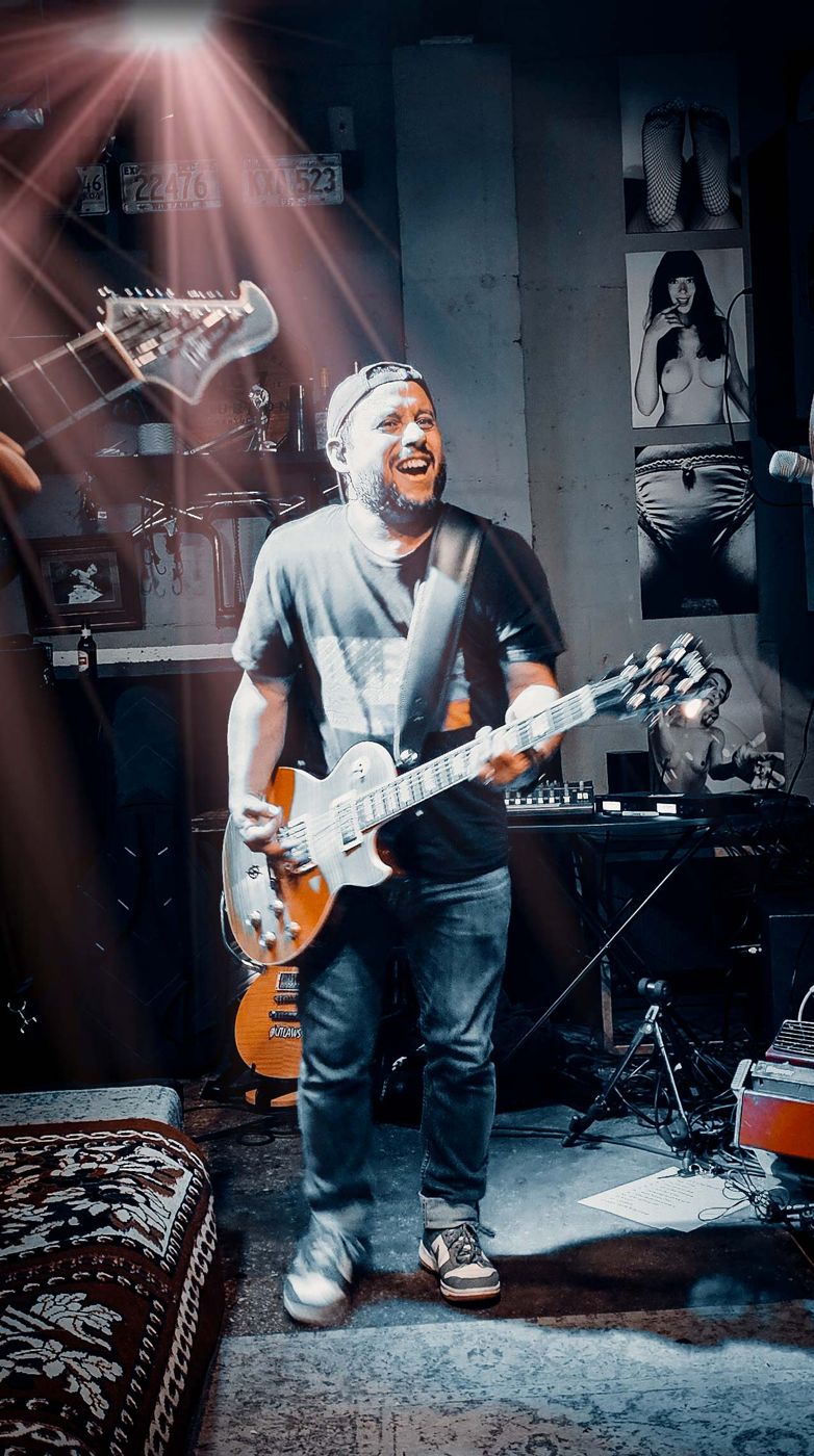 Guitarist laughing mid song in the rug room