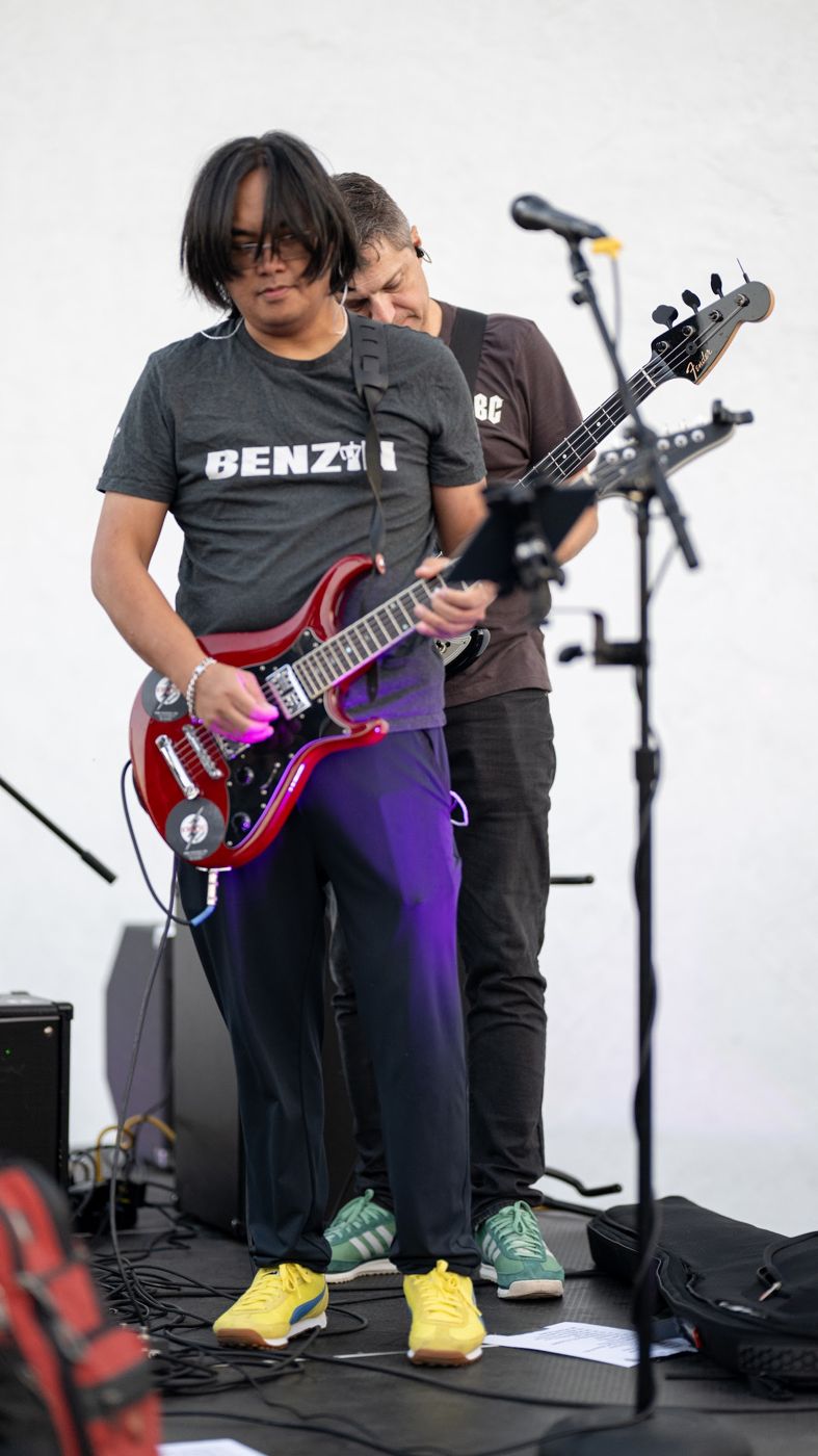 Guitarist with a red guitar on a white stage