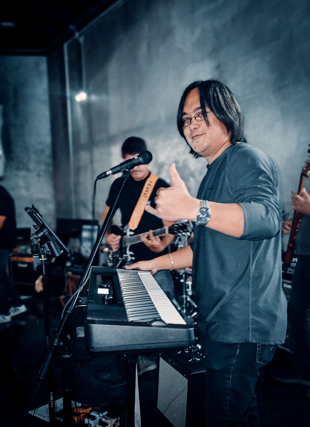 Keys player smiling mid song with a guitarist behind