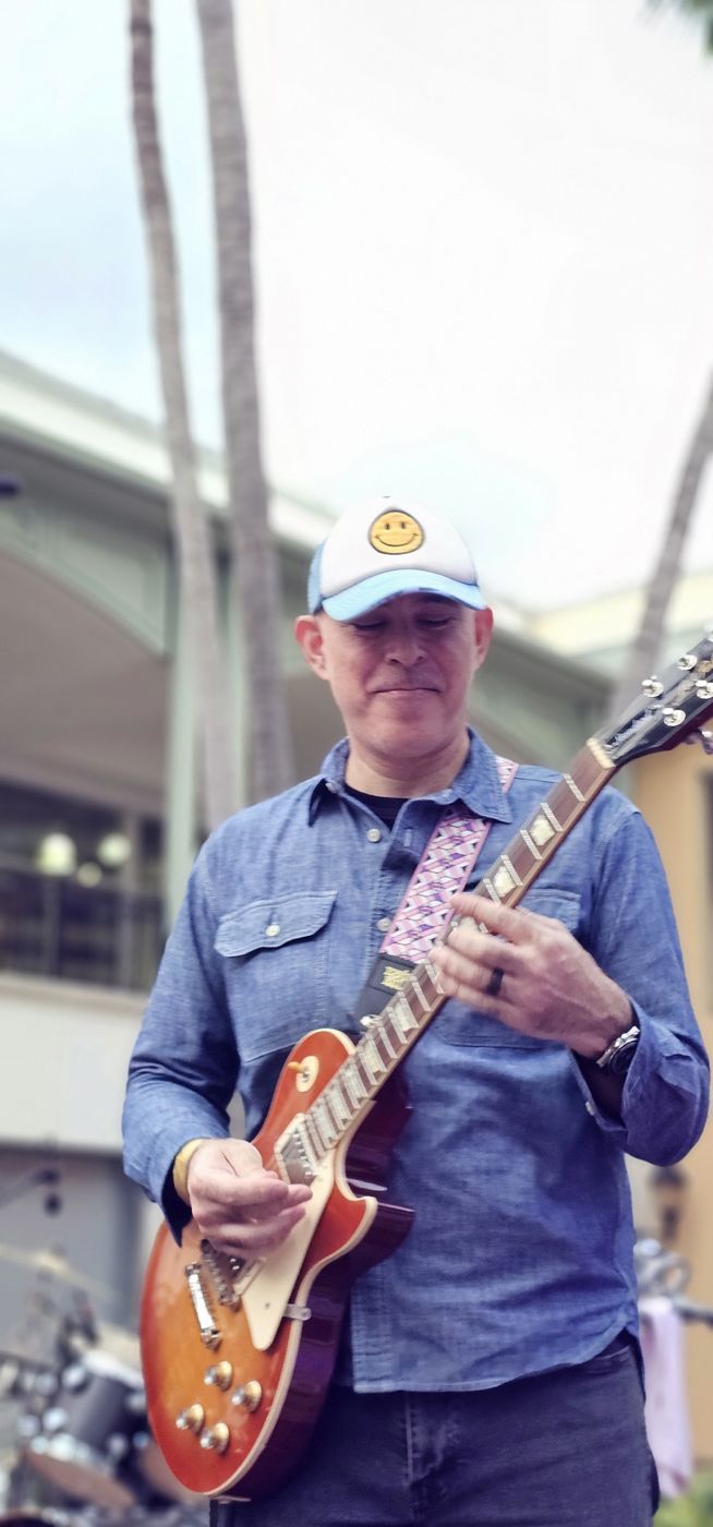 Guitarist playing an outdoor daytime show