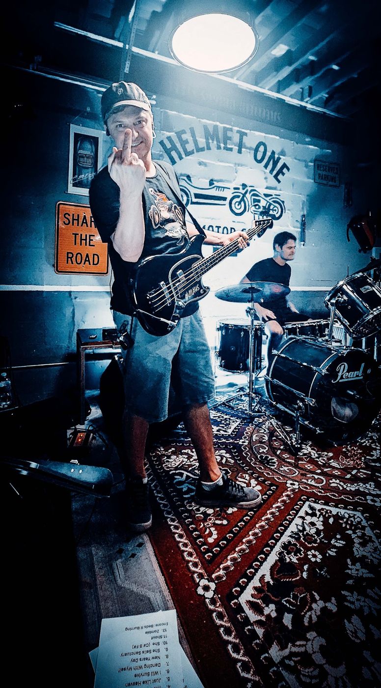 Bass player in front of the mural wall