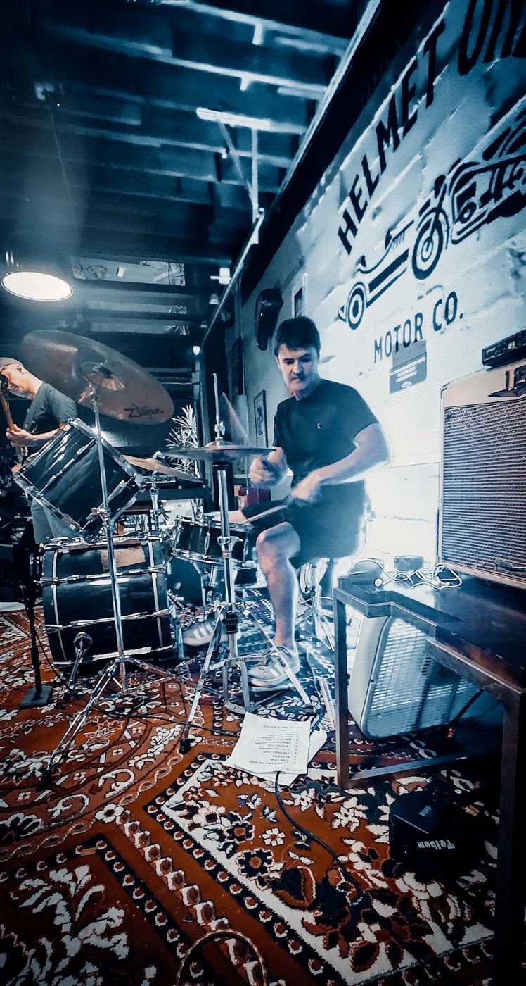 Drummer in the rug room under blue light