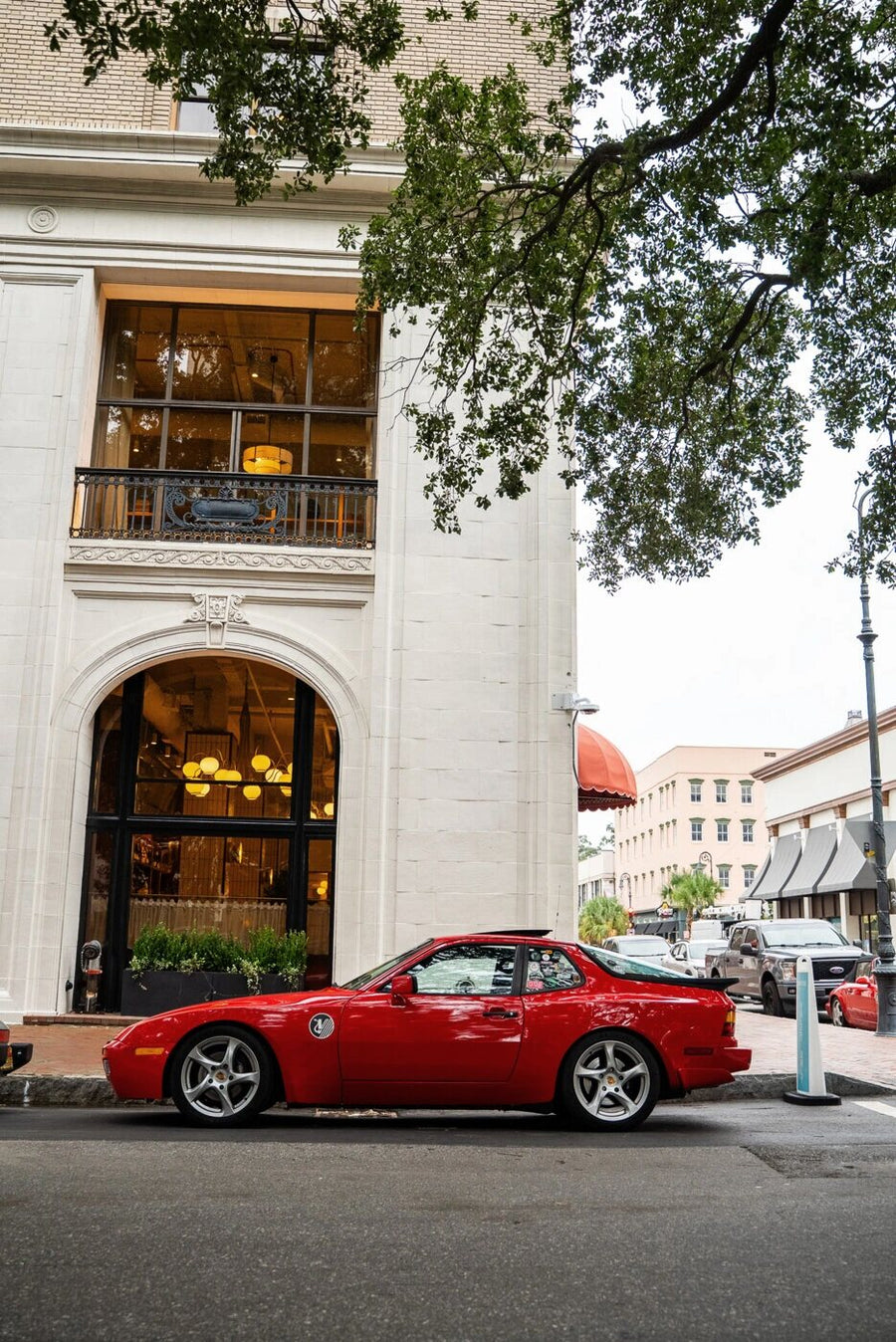 Red classic parked in front of a historic hotel